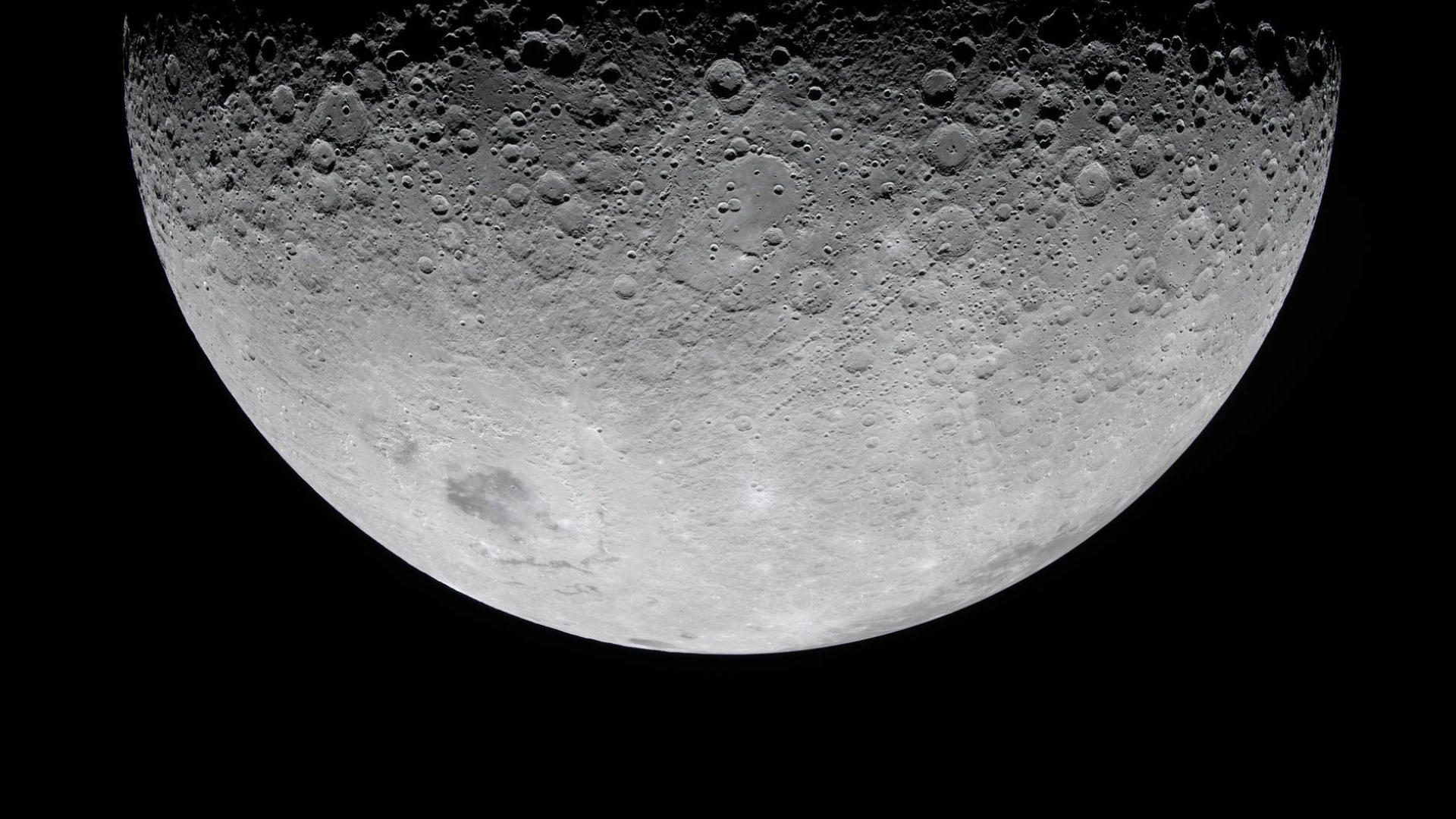 Uma fotografia em close-up de alta resolução da Lua, em fase minguante. Apenas a metade superior é visível, mostrando uma superfície cinzenta incrivelmente detalhada e densamente coberta por inúmeras crateras de impacto, contra o vazio negro e escuro do espaço.